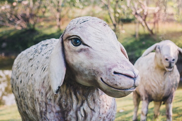 Naklejka premium Sheep statue in the garden background with vintage filter