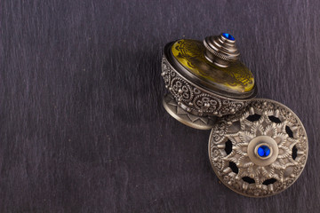 Silver Oriental Artisitc Arabian Oud Perfume / Arabian Oud Perfume with Oud Scented Wood burned in the background with Scented Smoke in the Air 