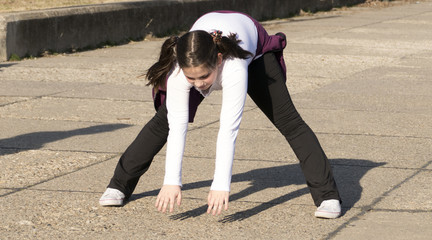 Fototapeta premium Little girl doing exercises in park