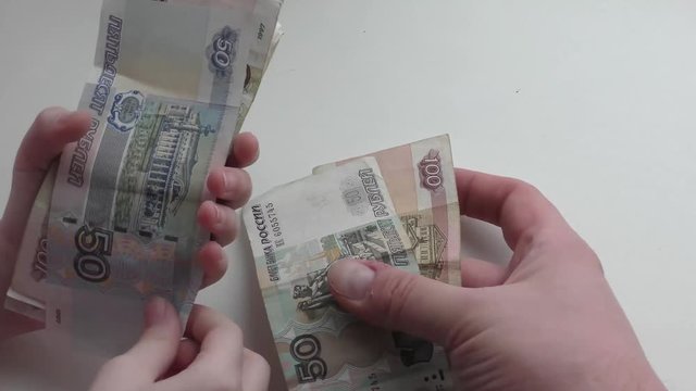 Руки ребенка перекладывают деньги в руки мужчины