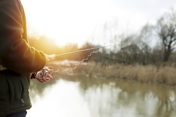 Fishing in river.A fisherman with a fishing rod on the river bank. Man fisherman catches a fish