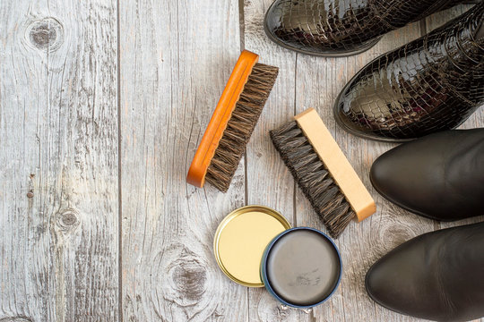 
 Shoes and care products for footwear on a gray wooden floor.