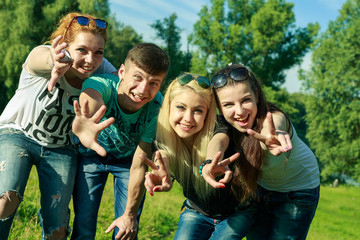 people, freedom, happiness, and teenage concept - group of happy friends go out and fun on a background of green trees