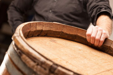 Man standing with his hand on an oak barrel