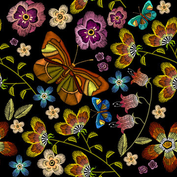 Embroidery flowers and butterflies seamless pattern. Beautiful camomiles, cornflowers, classical embroidery on black background