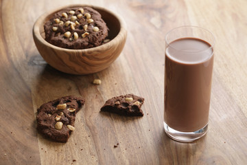 chocolate milk in glass with homemade chocolate cookies with hazelnuts, sweet breakfast
