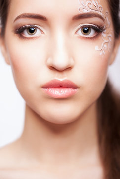 Close-up portrait of young woman with face art  make up