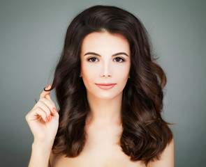 Beautiful Woman with Healthy Hair and Clear Skin touching her Hair. Haircare Concept