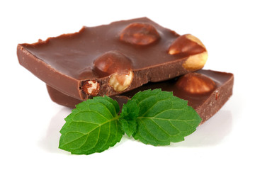Chocolate with hazelnuts with mint leaves isolated on white background