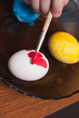 Painting Easter eggs with a brush,