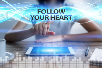 Woman using tablet pc, pressing on virtual screen and selecting follow your heart.