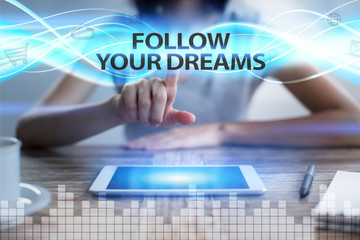 Woman using tablet pc, pressing on virtual screen and selecting follow your dreams.