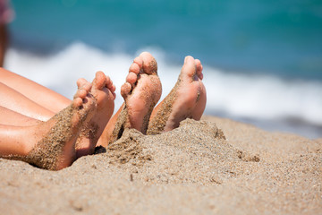 Family feet on a beach