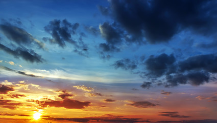 Sunset with sun rays, sky with clouds and sun.