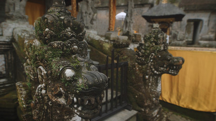 Close up of bronze dragon statues in temple on Bali island. Two oriental ancient sculptures of mythical beings are fixed to protect monkhood from evil spirits.