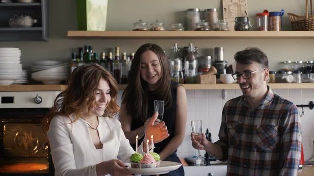 Birthday party, woman blows out the candles on cupcakes