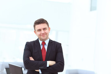 Successful businessman posing with crossed arms and smiling at camera