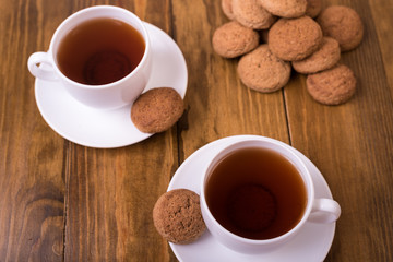 Tea and oaten cookies on a wooden table