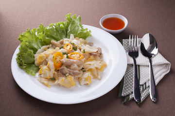 Fried noodle with chicken with sauce, spoon and fork for lunch