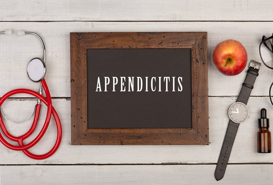 blackboard with text "Appendicitis", stethoscope and watch