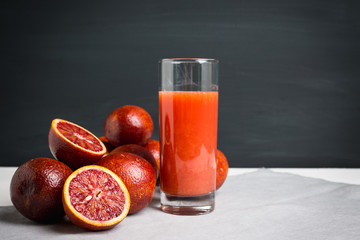 Red Sicilian oranges on the dark wooden background. Shallow depth of field.