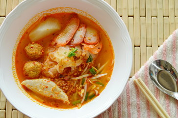 thin rice noodles topping slice barbecue pork and shrimp ball in spicy soup