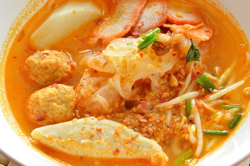 thin rice noodles topping slice barbecue pork and fish ball in tom yum soup