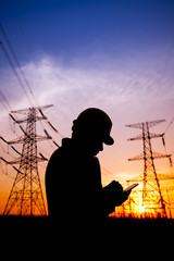 Electricity workers and pylon silhouette