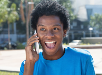 Happy young african american man at cellphone