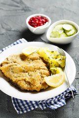 Classic schnitzel with lemon, potato, cucumber salad and berries