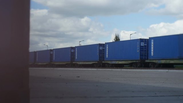 Motion from behind Corner to Train of Blue Railway Carriages