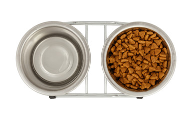 Two metal bowls for dogs and cats on a stand. View from above. One bowl is filled with fodder,  the...