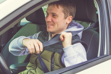 Young man fasten Safety belt. Safe driving