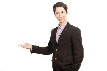 Handsome young businessman in suit smiling looking at camera holding a palm up