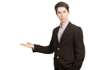 Handsome young businessman in suit smiling looking at camera holding a palm up