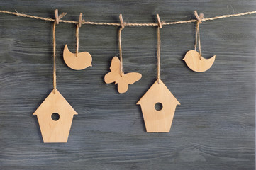 birds, birdhouses, butterflies on a rope on the background of wooden wall. Easter concept.