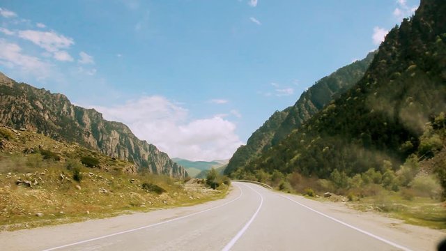 Driving by car along the highway among the mountains