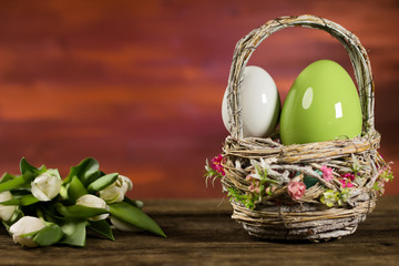 Easter theme eggs with tulips on wooden board, easter holiday concept. Copyspace for text.