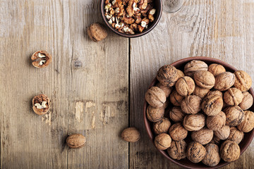 Obraz premium walnuts in a clay plate on a wooden background. top view