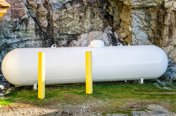 Propane Tank in front of a Rock Wall
