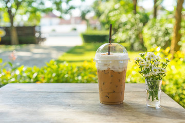 Iced coffee in Coffee shop ,Iced coffee with straws in plastic cup on wooden background, Selective focus