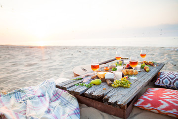 Picnic on the beach at sunset in boho style, food and drink concept - 141237607
