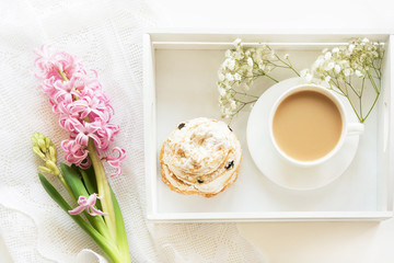 Morning breakfast in spring with a cup of black coffee with milk in the pastel colors, a bouquet of fresh pink hyacinth on a white background. Top view and copy space.
