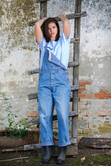 Young farm woman posing near ladder in front of a camera