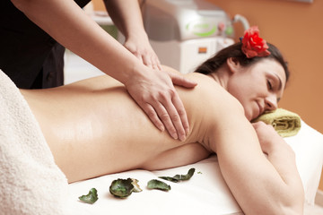 Obraz na płótnie Canvas beauty, holidays and spa concept - woman in spa salon getting massage