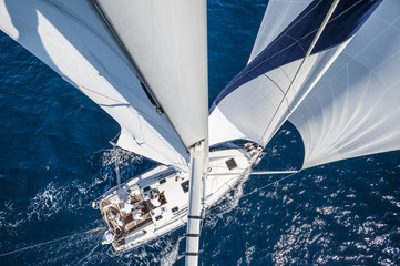 Sailing boat with spinnaker from top of the mast, motion blurred sea