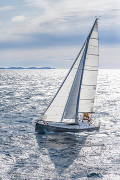 Small sailing boat sailing up wind in cold conditions
