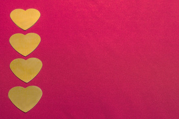 Four yellow hearts vertically in a row on the left side of the red factory material, toned.