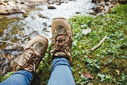 Hiking shoes on hiker outdoors walking crossing river creek. Woman  and men on hike trekking in nature. Close up of hiking boots.