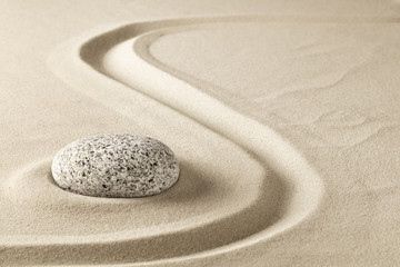 Fototapeta na wymiar zen meditation stone in sand. Concept for purity harmony and spirituality. Spa wellness and yoga background.